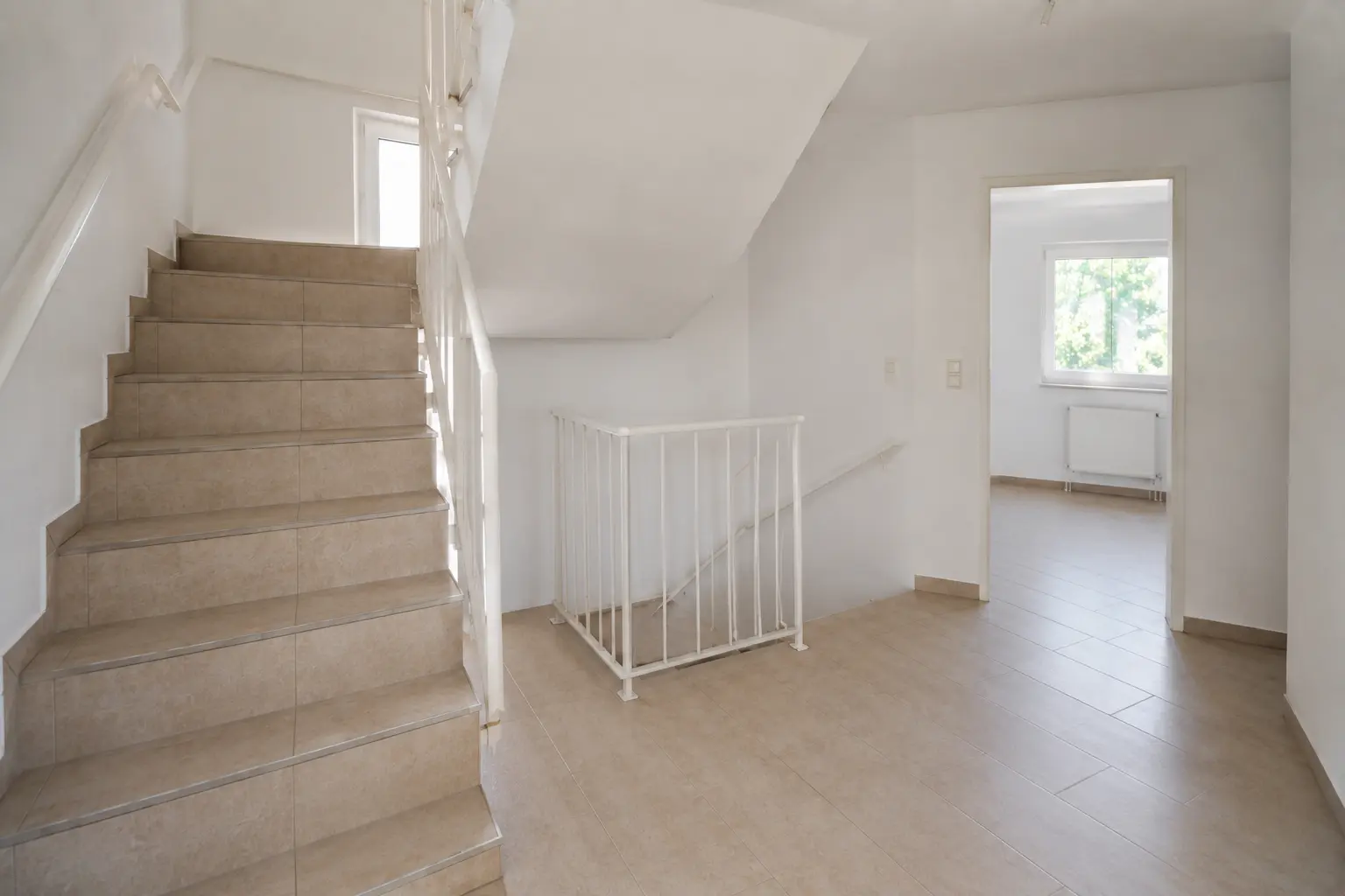 Treppenhaus eines Mehrfamilienhauses mit Blick in eine Wohnung