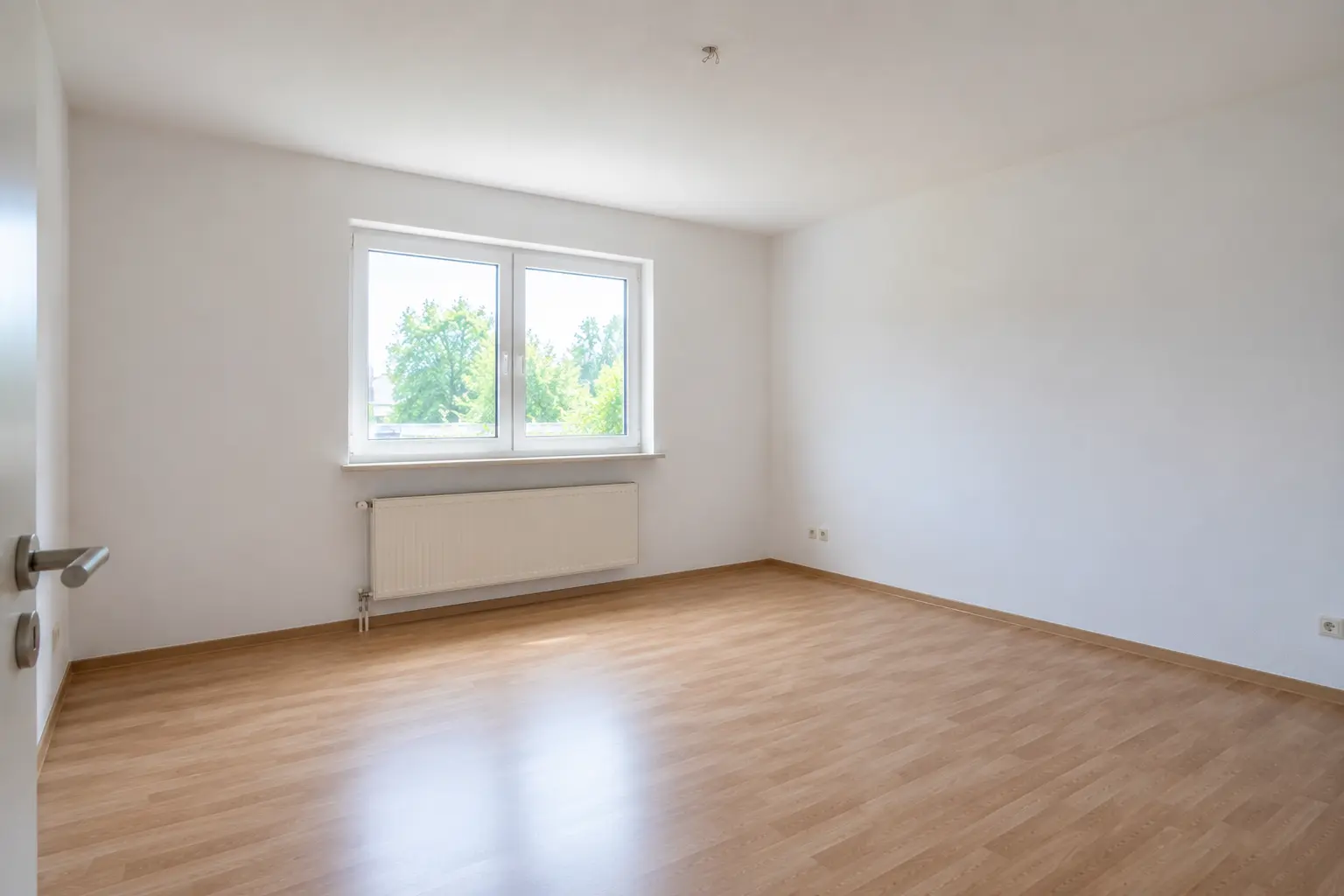 Heller Raum mit großem Fenster und Laminatboden